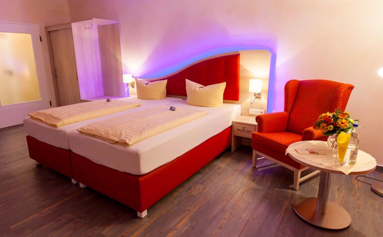 Hotelzimmer mit Doppelbett und Sessel