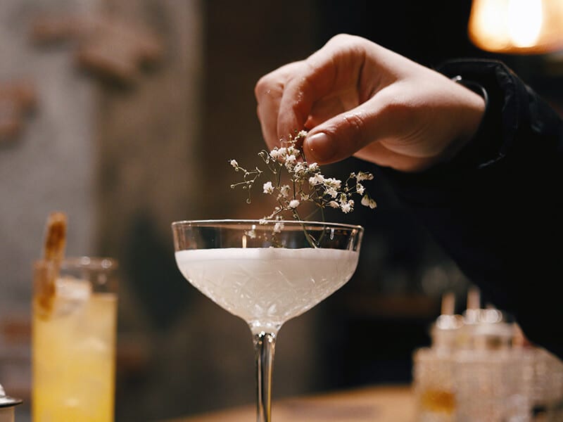 Ein heller Cocktail wird an der Bar angerichtet